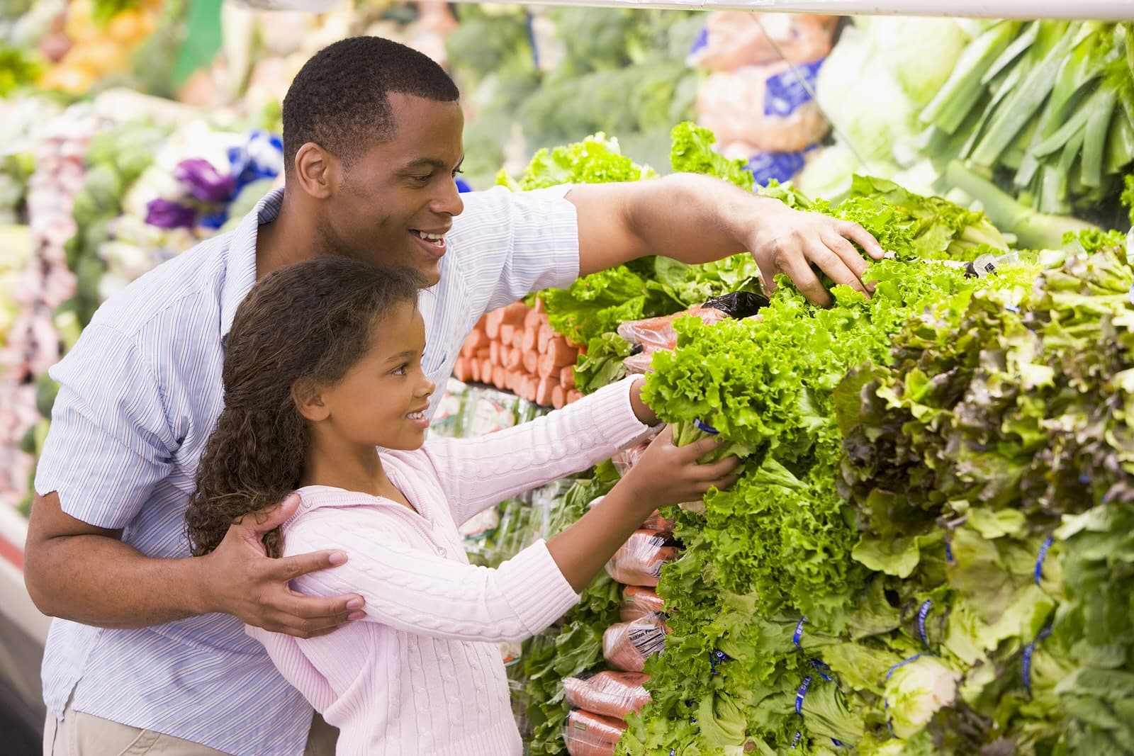 Man and child in grocery store choosing lettuce; doctors prescribing produce