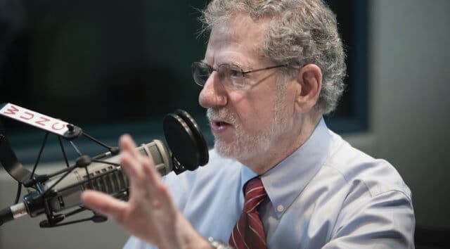 Joe Graedon talking into a radio microphone at WUNC public radio stations.